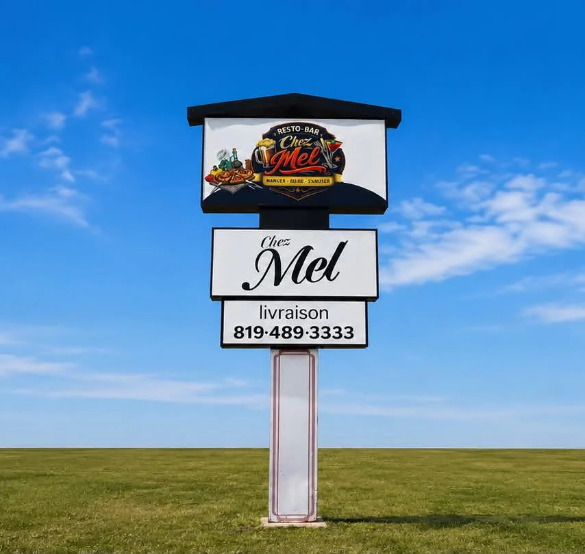 Enseigne du Resto-bar Chez Mel sur poteau : logo, panneau « Chez Mel » et panneau « livraison 819·489·3333 »
